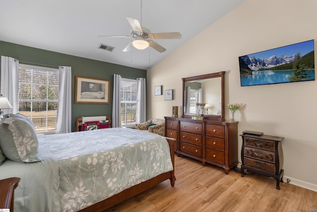 bedroom with visible vents, multiple windows, wood finished floors, and vaulted ceiling
