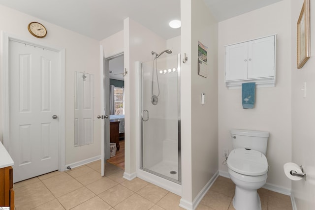 bathroom featuring vanity, baseboards, a stall shower, tile patterned flooring, and toilet