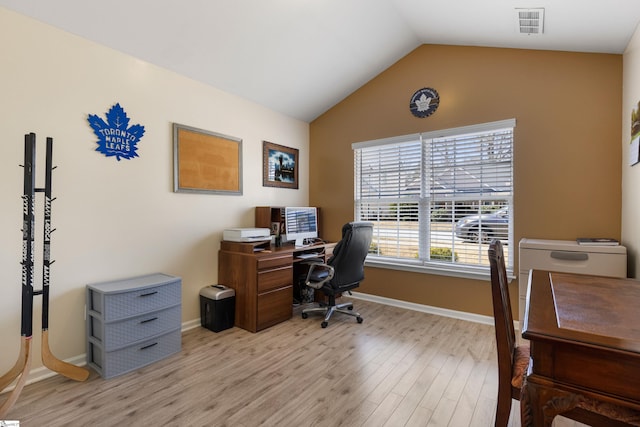 office space featuring light wood finished floors, visible vents, baseboards, and lofted ceiling