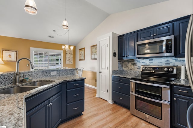 kitchen with light wood finished floors, a sink, stainless steel appliances, vaulted ceiling, and a notable chandelier