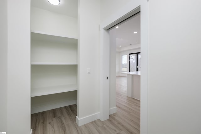 corridor featuring recessed lighting, baseboards, and wood finished floors