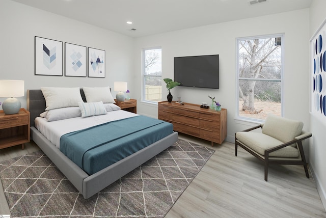 bedroom with recessed lighting, wood finished floors, visible vents, and baseboards
