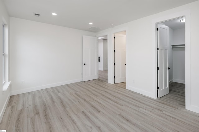 unfurnished bedroom featuring recessed lighting, light wood-style flooring, visible vents, and baseboards