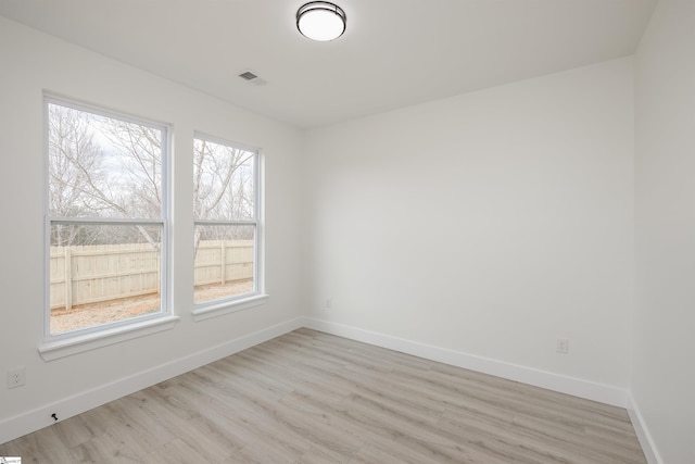 spare room with visible vents, baseboards, and light wood finished floors
