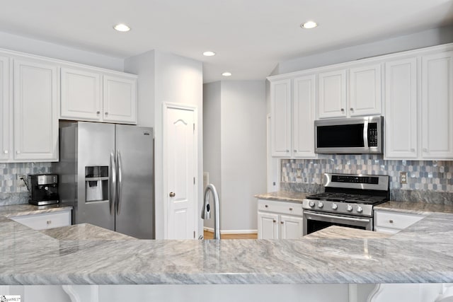39 Santee Ct, Simpsonville, SC 29680 - kitchen with white cabinetry, light stone countertops, tasteful backsplash, and stainless steel appliances