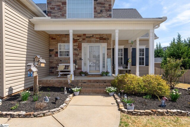 39 Santee Ct, Simpsonville, SC 29680 - view of exterior entry with stone siding, a porch, and fence