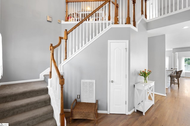 39 Santee Ct, Simpsonville, SC 29680 - staircase featuring visible vents, baseboards, a high ceiling, and wood finished floors