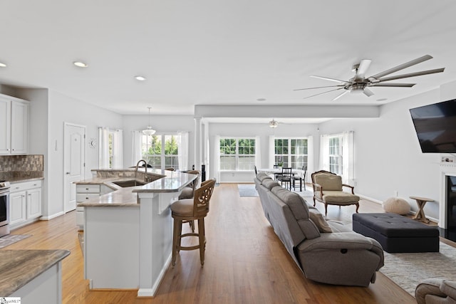 39 Santee Ct, Simpsonville, SC 29680 - kitchen with light wood-type flooring, a ceiling fan, open floor plan, and a sink