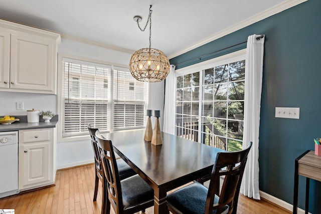 dining room featuring light wood-type flooring, an inviting chandelier, and crown molding