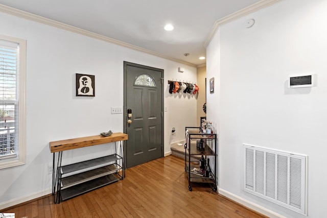 entrance foyer with visible vents, crown molding, baseboards, recessed lighting, and wood-type flooring