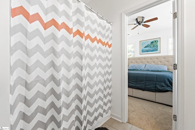 ensuite bathroom featuring curtained shower, a ceiling fan, ensuite bathroom, and tile patterned flooring