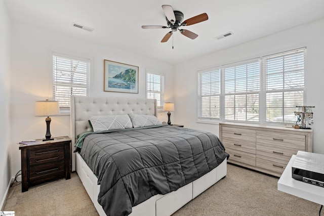 bedroom with light colored carpet, visible vents, and ceiling fan