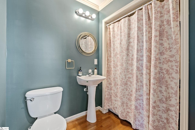 full bathroom featuring toilet, ornamental molding, wood finished floors, a shower with shower curtain, and baseboards