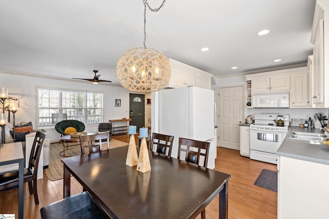 dining space with ceiling fan with notable chandelier, recessed lighting, light wood-style floors, and ornamental molding