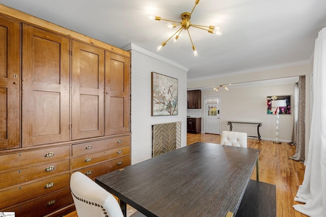 dining space featuring an inviting chandelier, light wood-style floors, baseboards, and ornamental molding