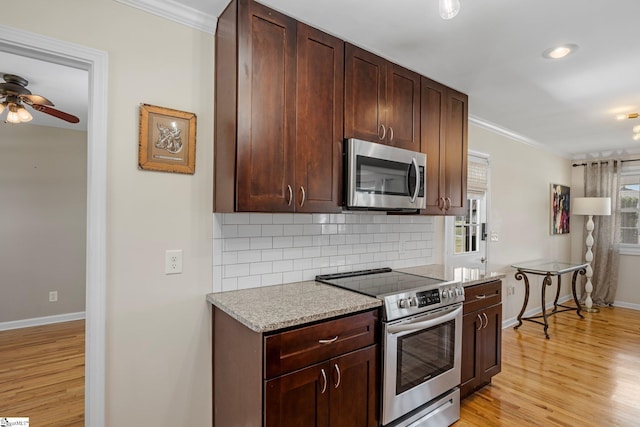 kitchen with a ceiling fan, backsplash, light wood-style floors, appliances with stainless steel finishes, and crown molding