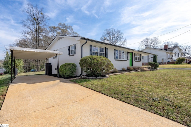 view of front of house with a carport, a chimney, concrete driveway, and a front lawn