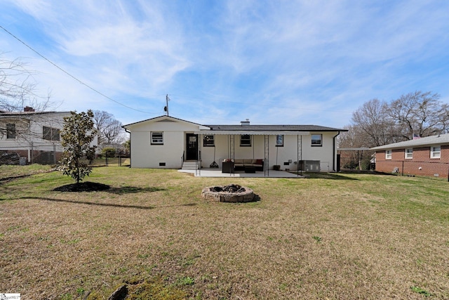 rear view of property with a yard, fence, an outdoor living space with a fire pit, and a patio area