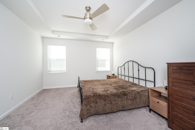 bedroom with visible vents, baseboards, carpet floors, a tray ceiling, and ceiling fan