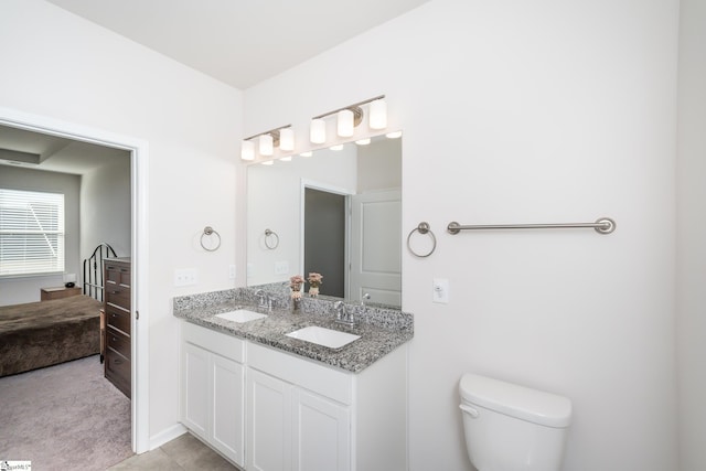 full bathroom featuring double vanity, toilet, and a sink