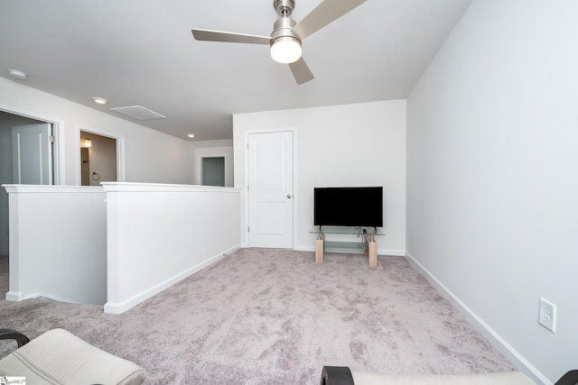 unfurnished room with an upstairs landing, baseboards, ceiling fan, and carpet floors