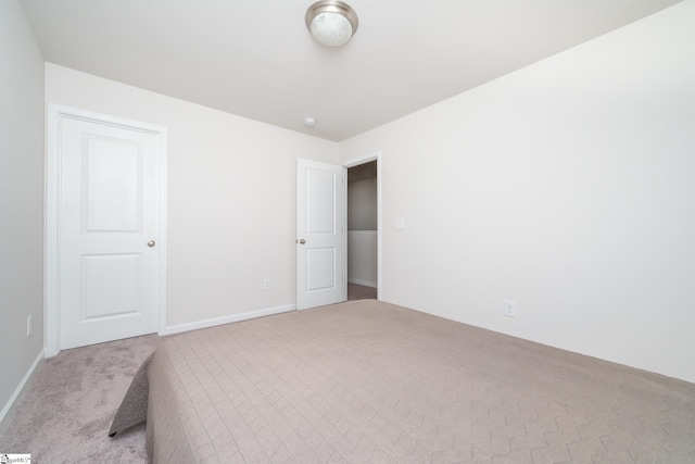 unfurnished bedroom featuring carpet and baseboards