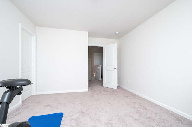 exercise room with carpet flooring and baseboards