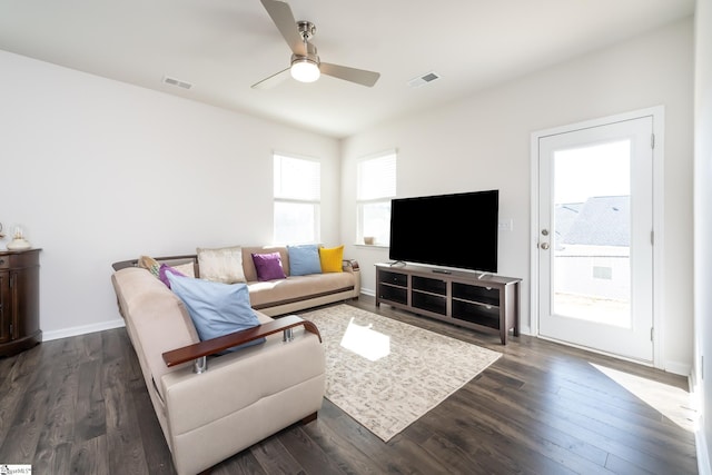 living room with visible vents, a healthy amount of sunlight, and dark wood-type flooring