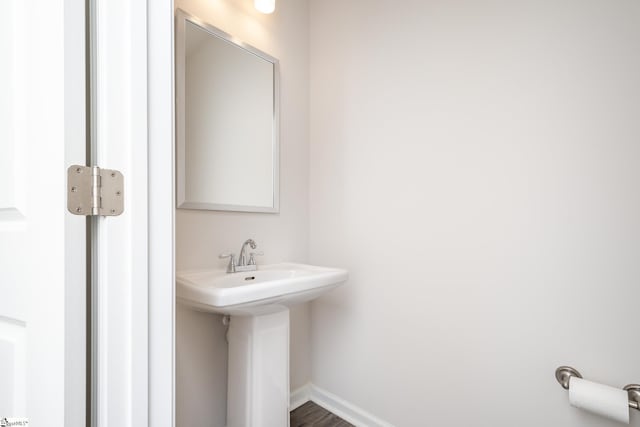 bathroom featuring baseboards and a sink