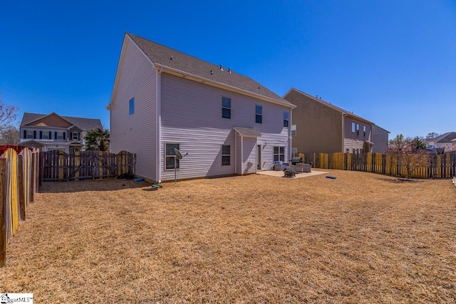 back of property featuring a patio, a yard, and a fenced backyard