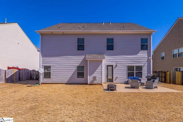 rear view of house with a yard, a patio, a fenced backyard, and an outdoor fire pit