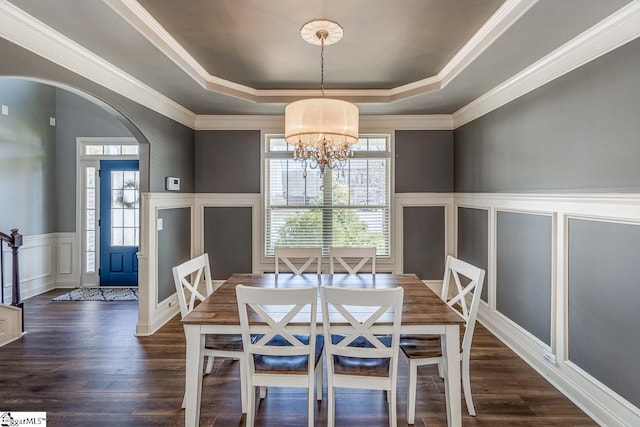 dining space featuring a raised ceiling, arched walkways, and a wealth of natural light