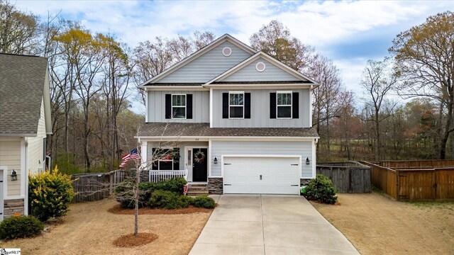 212 Donemere Way, Fountain Inn, SC 29644 - view of front of property with board and batten siding, fence, a garage, stone siding, and driveway