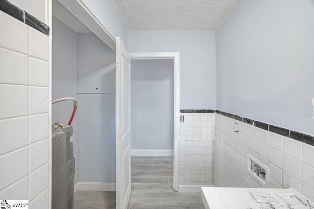 139 Randolph Ct, Woodruff, SC 29388 - bathroom with tile walls, wood finished floors, a wainscoted wall, and a textured ceiling