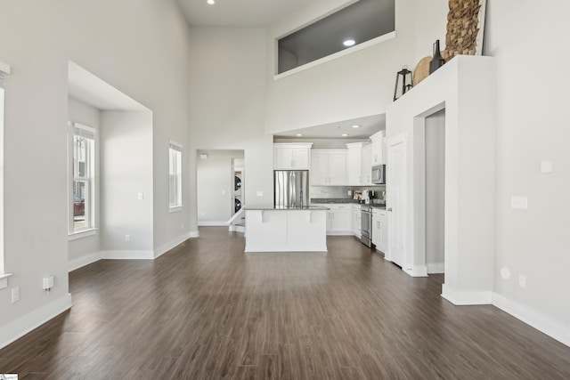 31 Creekhaven Ln, Taylors, SC 29687 - unfurnished living room featuring recessed lighting, baseboards, a towering ceiling, and dark wood-style flooring