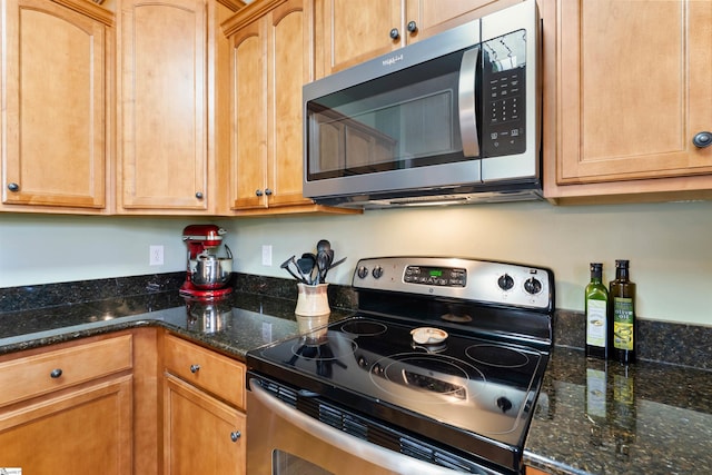 kitchen with dark stone counters and stainless steel appliances