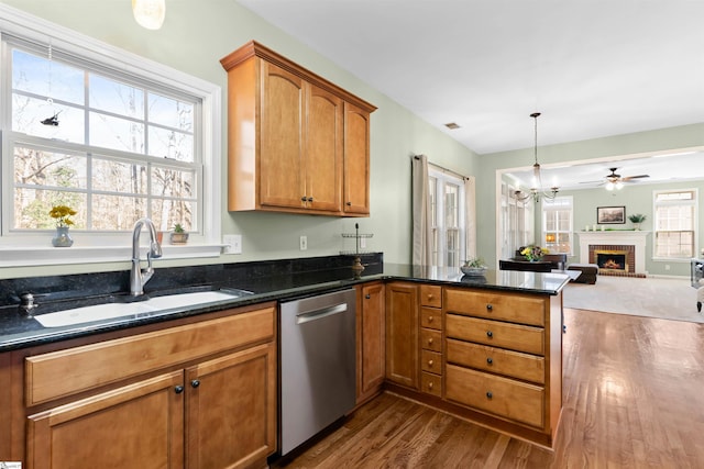 kitchen with a peninsula, a sink, dark wood-type flooring, dishwasher, and open floor plan