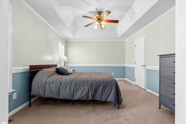 carpeted bedroom featuring crown molding, baseboards, a raised ceiling, and ceiling fan