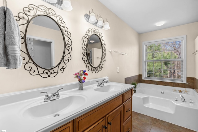 bathroom with tile patterned floors, a garden tub, double vanity, and a sink