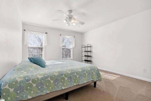bedroom with a ceiling fan, baseboards, and carpet floors