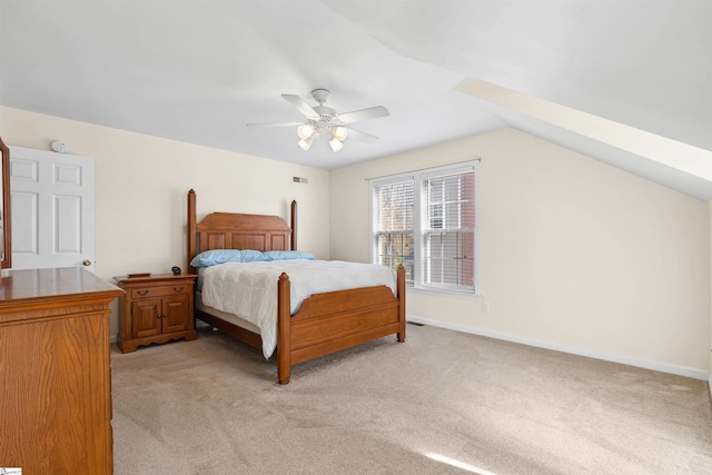 bedroom with vaulted ceiling, light colored carpet, baseboards, and ceiling fan