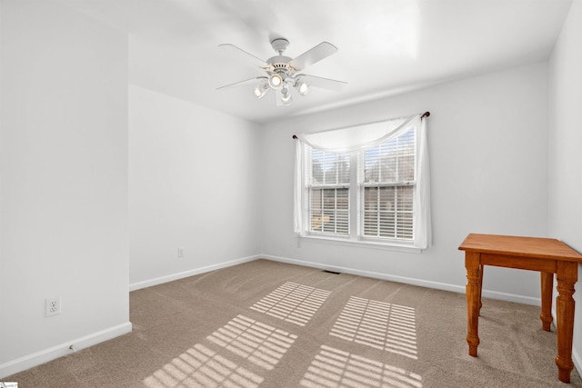 empty room featuring visible vents, carpet, baseboards, and ceiling fan