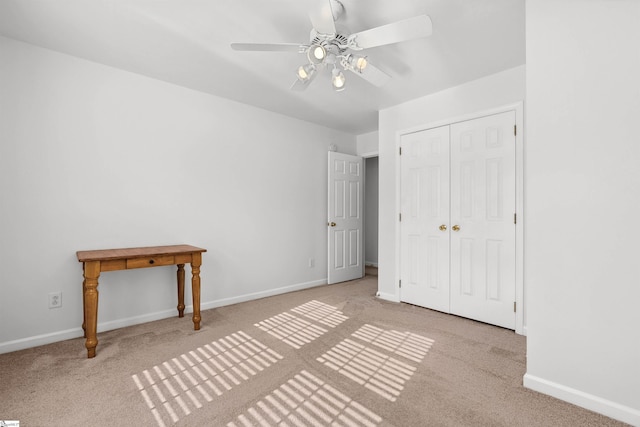 unfurnished bedroom featuring carpet flooring, a ceiling fan, baseboards, and a closet