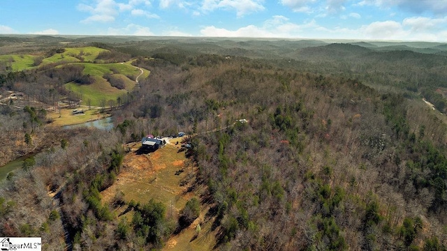 bird's eye view with a wooded view
