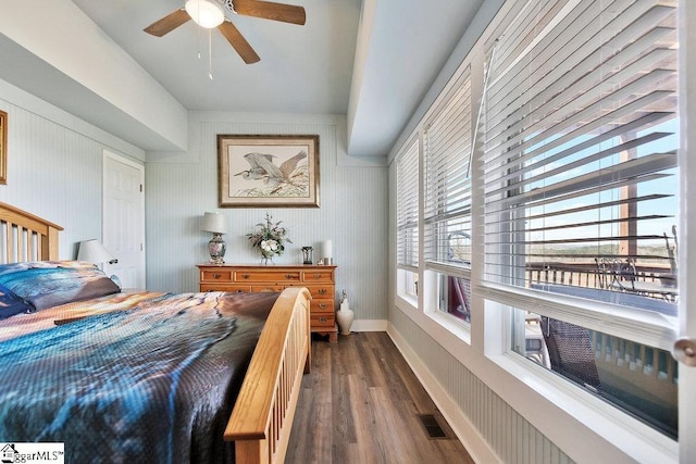 bedroom featuring visible vents, baseboards, dark wood finished floors, and a ceiling fan