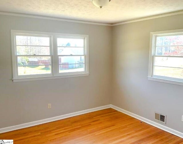 spare room with light wood finished floors, baseboards, and visible vents