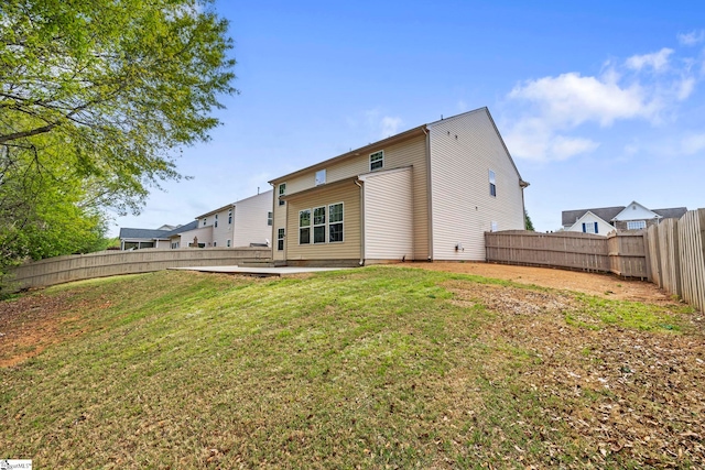 back of house with a yard, a fenced backyard, and a patio