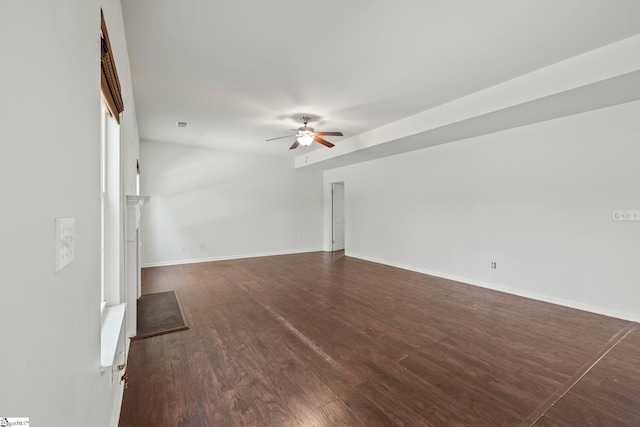 unfurnished living room with dark wood-style floors, baseboards, and ceiling fan