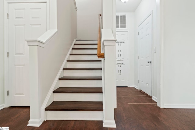 stairs with visible vents, baseboards, and wood finished floors