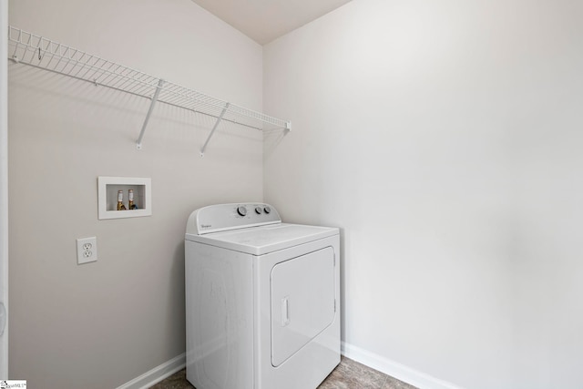 clothes washing area with washer / dryer, laundry area, and baseboards